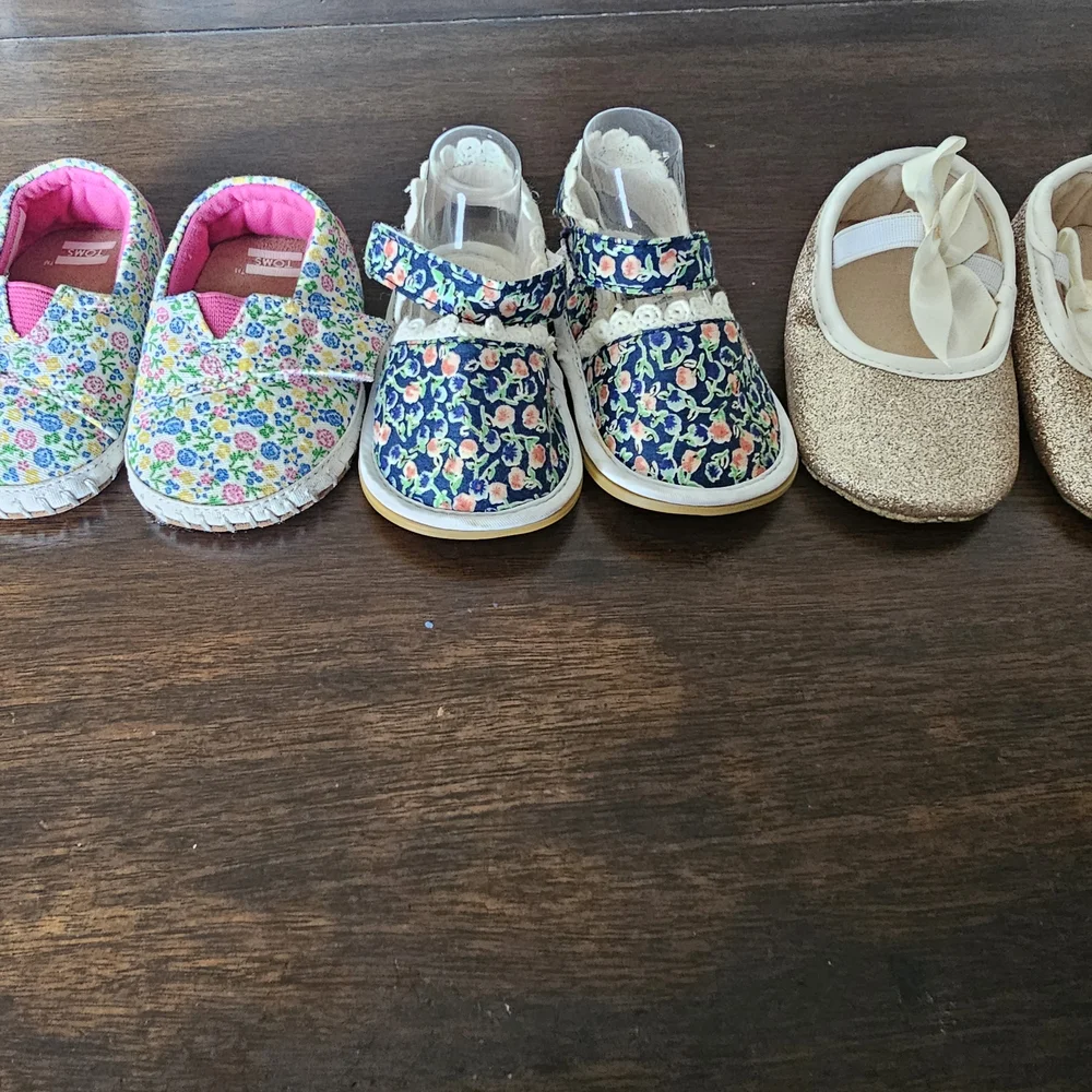 3 pairs of baby/girl shoes—soft, floral, and glittery—in various styles.